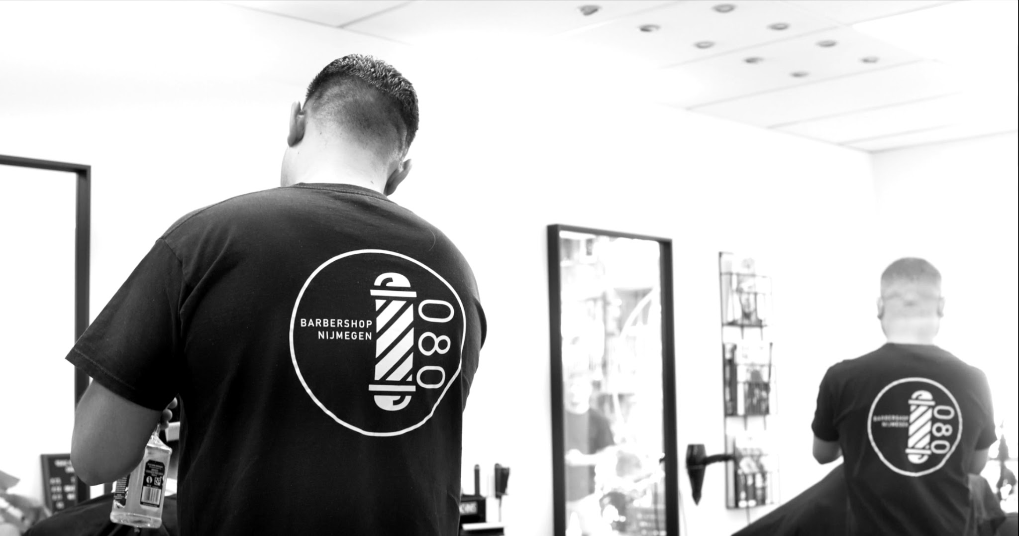 De barbiers in zwarte shirts met de eigen 080-belettering
