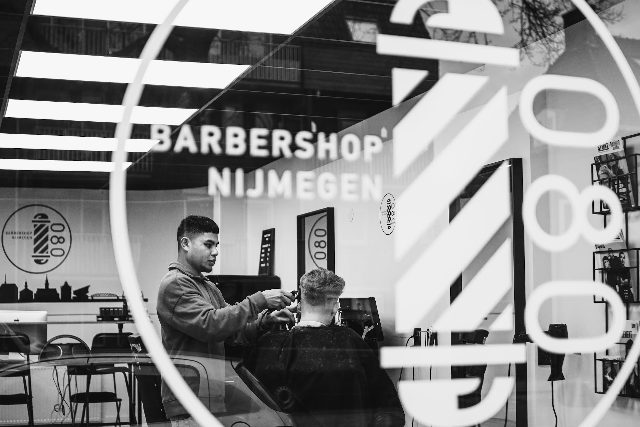 De spiegel in de barbershop met Barbershop Nijmegen en 080-belettering